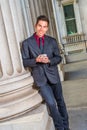 Young man standing outside office in New York City, texting on cell phone Royalty Free Stock Photo