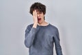 Young man standing over isolated background yawning tired covering half face, eye and mouth with hand Royalty Free Stock Photo