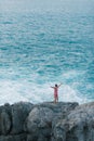 Young man standing on the sea-cliff with his arm in the air and enjoy the view Royalty Free Stock Photo