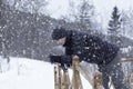 A guy leaning on the railing in the park in heavy snow weather Royalty Free Stock Photo