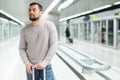 Young man standing with suitcase on subway station platform Royalty Free Stock Photo