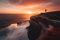 Young man standing on the top of rock and looking at the seashore and mountains at colorful sunset in summer. Landscape, sea, Royalty Free Stock Photo