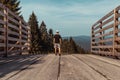 Young man standing on top of wood crossover with trees and hill, Sumava National Park, Czech republic and Germany