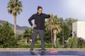 Young man standing vertically holding a mop for solar panel cleaning in the hand with vegetation in the background Royalty Free Stock Photo