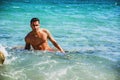 Young man standing in water by sea or ocean shore, Royalty Free Stock Photo