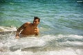 Young man standing in water by sea or ocean shore, Royalty Free Stock Photo