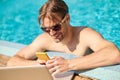 Young man standing in water in a swimming pool and texting a message Royalty Free Stock Photo