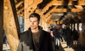 Young man standing on wooden footbridge in Switzerland while looking away