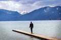 Young man stands alone on the jetty in the tegernsee lake Royalty Free Stock Photo