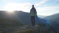 Young man stands high on top of the big mountain at beautiful sunset Royalty Free Stock Photo