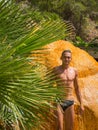 A young man is stands near a hot mineral spring. Turkey. Karahayit (near the city of Denizli) - red-brown-orange travertine with Royalty Free Stock Photo