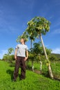 Young man stands next to pawpaw tree Royalty Free Stock Photo