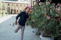 a young man stands on the street near a bush and happily sniffs Royalty Free Stock Photo