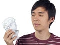 Young man stares at Roman bust in his hand