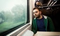 Young man staring out the train window. Royalty Free Stock Photo