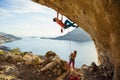 Young man starts climbing in cave, his female partner belaying him Royalty Free Stock Photo