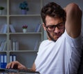 Young man staying late in office to do overtime work Royalty Free Stock Photo