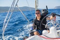 Young man steers a sailing yacht boat in the open sea. Sport. Royalty Free Stock Photo