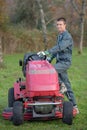 Young man stepping on to mower Royalty Free Stock Photo