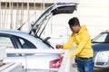 Young man storing a bag in trunk Royalty Free Stock Photo