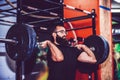 Young man straining to lift heavy weights during a workout session in a gym Royalty Free Stock Photo