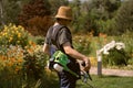 A young man with a lawnmower cares for the grass in the backyard. Royalty Free Stock Photo