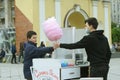 Young man street sweets seller selling cotton candy to the teen boy. Royalty Free Stock Photo