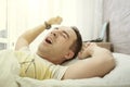 Young man stretching while waking up in the morning. Man yawning while waking up. Lazy young man in sleep. man yawns and