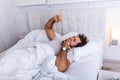 Young man stretching while waking up in the morning. Man yawning while waking up. Lazy young man in sleep. Portrait of man yawns