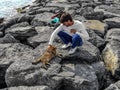 Young man stroking a homeless cat on the shore of the Sea of Marmara in Istanbul Turkey. Adult cute european guy and ginger