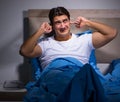 Young man struggling from noise in bed Royalty Free Stock Photo