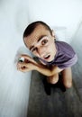 Feeling exposed. A young man stuck in a toilet trying to reach a tiny roll of toilet paper. Royalty Free Stock Photo