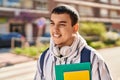 Young man student smiling confident holding books at street Royalty Free Stock Photo