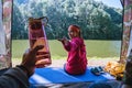 Young man submitting a bottle of drinking water to lover at camping tent facial