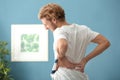 Young man suffering from back pain at home