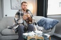 Young man suffering from cold at his home. Shot of a young man sitting on his bed while feeling unwell at home. Trying Royalty Free Stock Photo