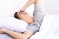 Young man suffering from headaches after wake up on the bed. Healthcare medical or daily life concept Royalty Free Stock Photo