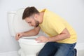 Young man suffering from nausea over toilet bowl Royalty Free Stock Photo