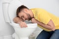 Young man suffering from nausea over toilet bowl Royalty Free Stock Photo