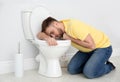 Young man suffering from nausea over toilet bowl Royalty Free Stock Photo