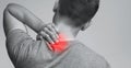 Young man suffering from neck ache, monochrome panorama photo