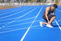 young man suffering from sudden ankle and leg pain during the workout at the stadium