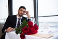 young man in suit with bouquet of red roses waiting for girlfriend Royalty Free Stock Photo