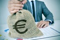 Young man in suit with a burlap money bag with the euro sign