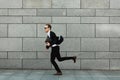 Young man in suit with folder is jumping to new job. Unlimited happiness and joy Royalty Free Stock Photo