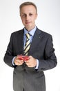 Young Man in Suit Posing with Red cellphone. against White Background Royalty Free Stock Photo
