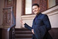 A young man in a suit shows a luxury house for sale. A benevolent realtor