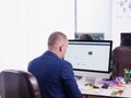 Young man in suit, sitting at desk in front of computer. Royalty Free Stock Photo