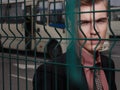 Young man in suit standing behind the grid Royalty Free Stock Photo