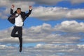 Young businessman wearing suit and tie jumping into cloudy sky success and freedom life Royalty Free Stock Photo